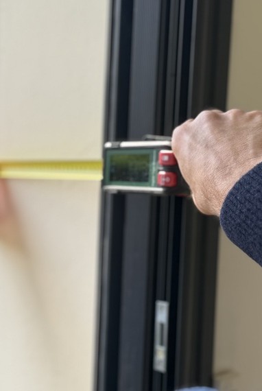 Électricien testant un tableau électrique avec gants isolants et multimètre